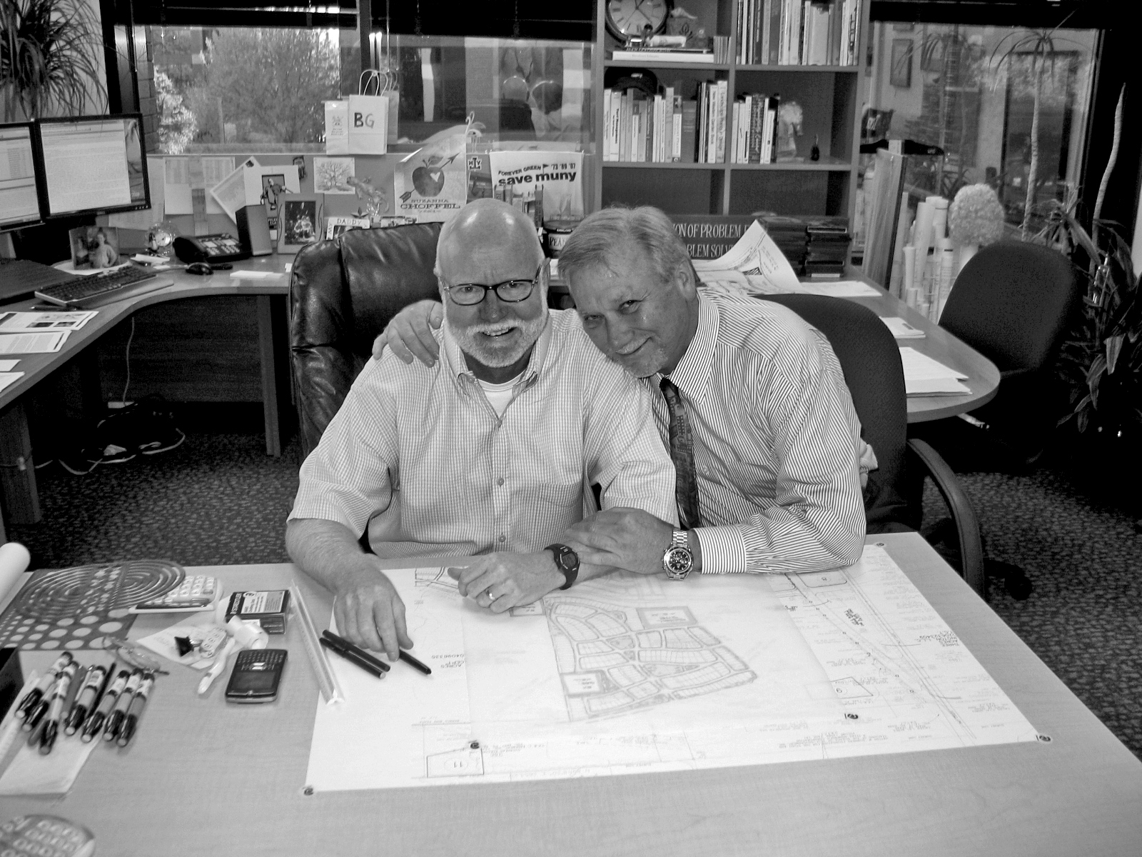 Tom and Earl sitting at a desk, looking jovial.